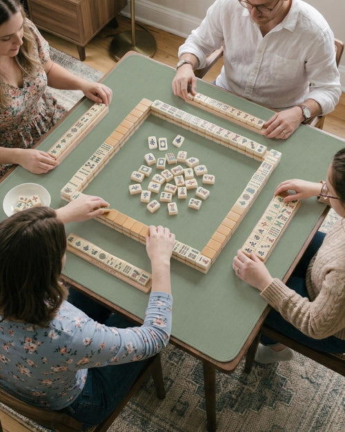 A square sage green mahjong mat shown as a plain green tabletop play surface.