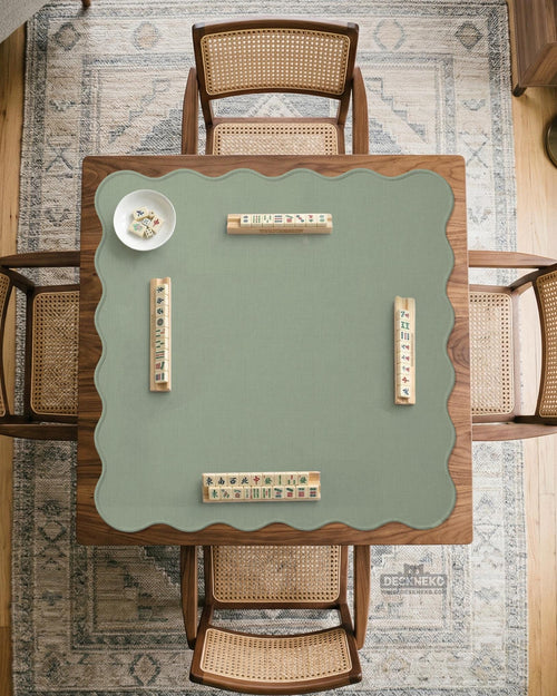 A square sage green mahjong mat with scalloped edges on a plain background.