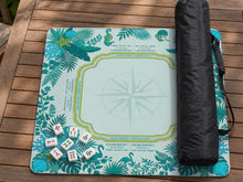 Aqua square mahjong mat with a botanical border and printed American Mahjong rule layout, including Charleston reminders and tile reference details.