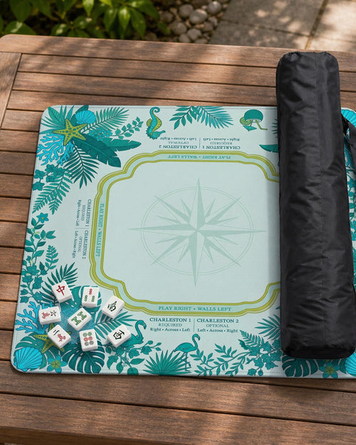 Aqua square mahjong mat with a botanical border and printed American Mahjong rule layout, including Charleston reminders and tile reference details.