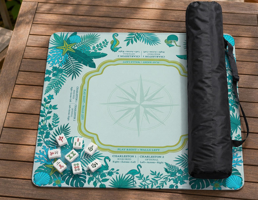 Aqua square mahjong mat with a botanical border and printed American Mahjong rule layout, including Charleston reminders and tile reference details.