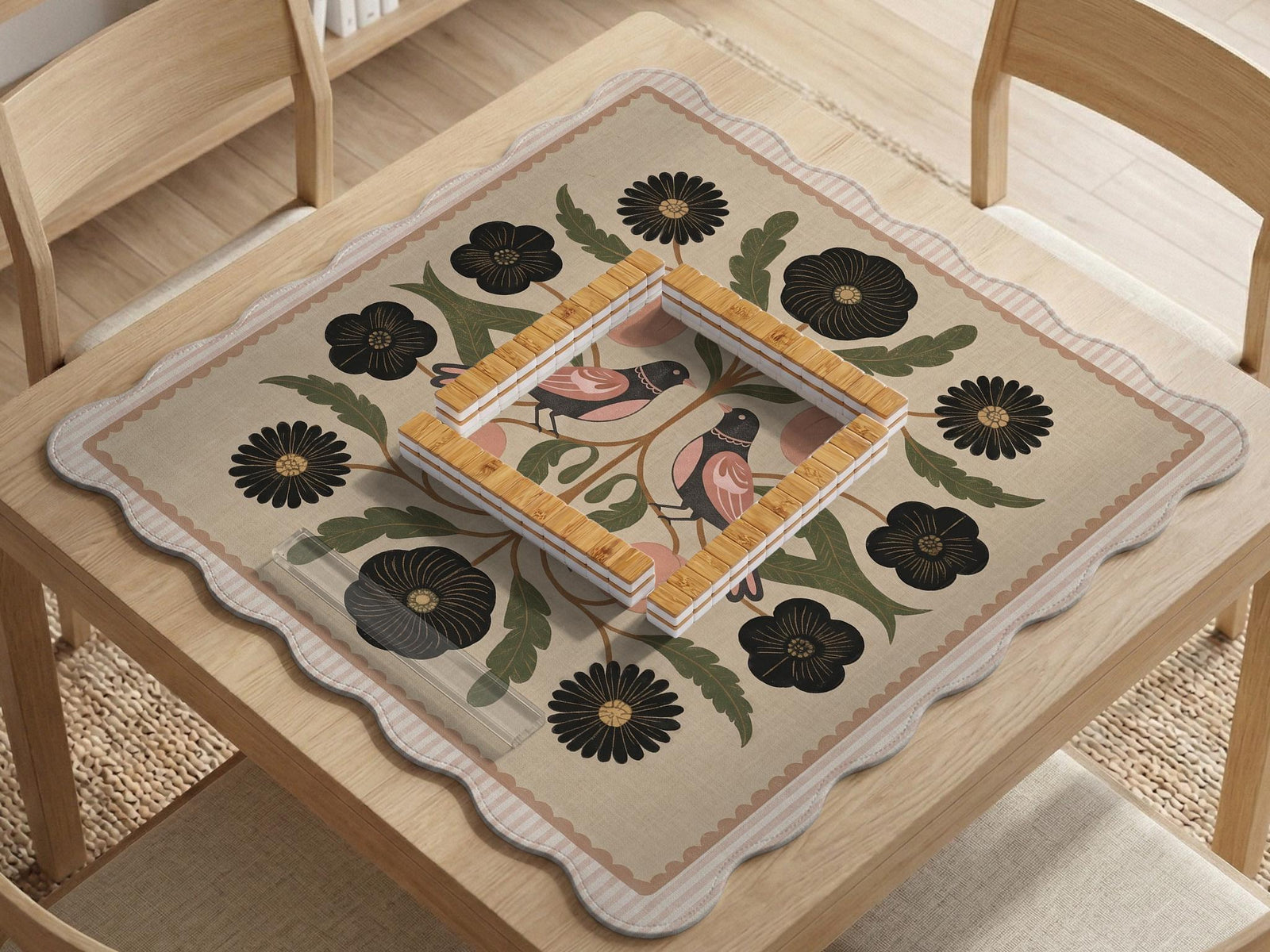 Beige mahjong mat with a botanical floral bird design, blush flowers, olive green leaves, black flower accents, and a warm linen-style background. Scalloped edge option shown.