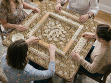 Beige mahjong mat with a white blossom branch floral pattern on a neutral background.
