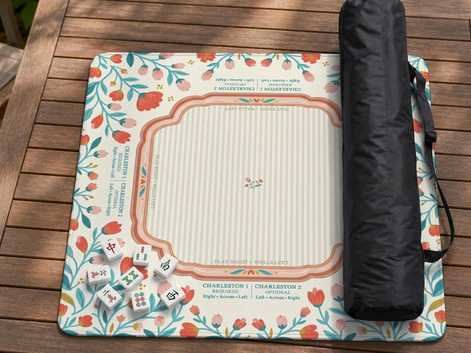 Square mahjong mat with a cream background, coral and teal folk floral border, and printed rules and tile layout details in the center.