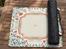 Square mahjong mat with a cream background, coral and teal folk floral border, and printed rules and tile layout details in the center.