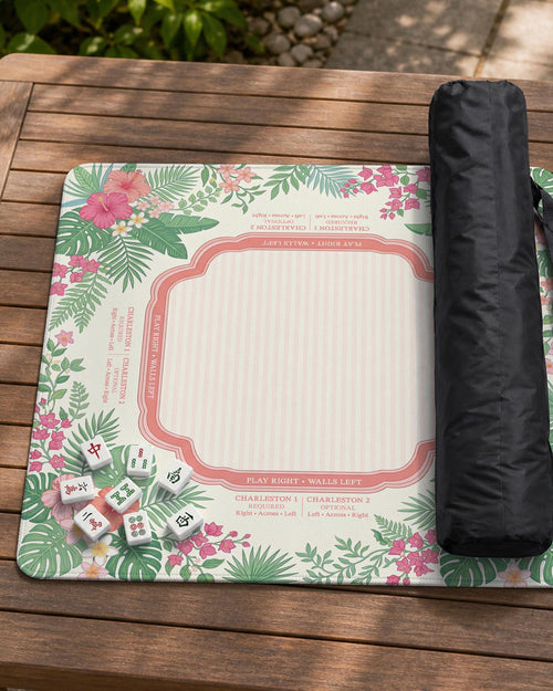Coral pink mahjong mat with hibiscus flowers, palm leaves, cream rule boxes, and decorative tropical patterning.