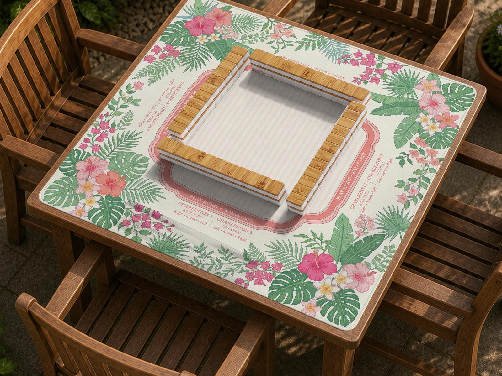 Cream mahjong mat with coral pink hibiscus flowers, green palm leaves, and printed rule zones.