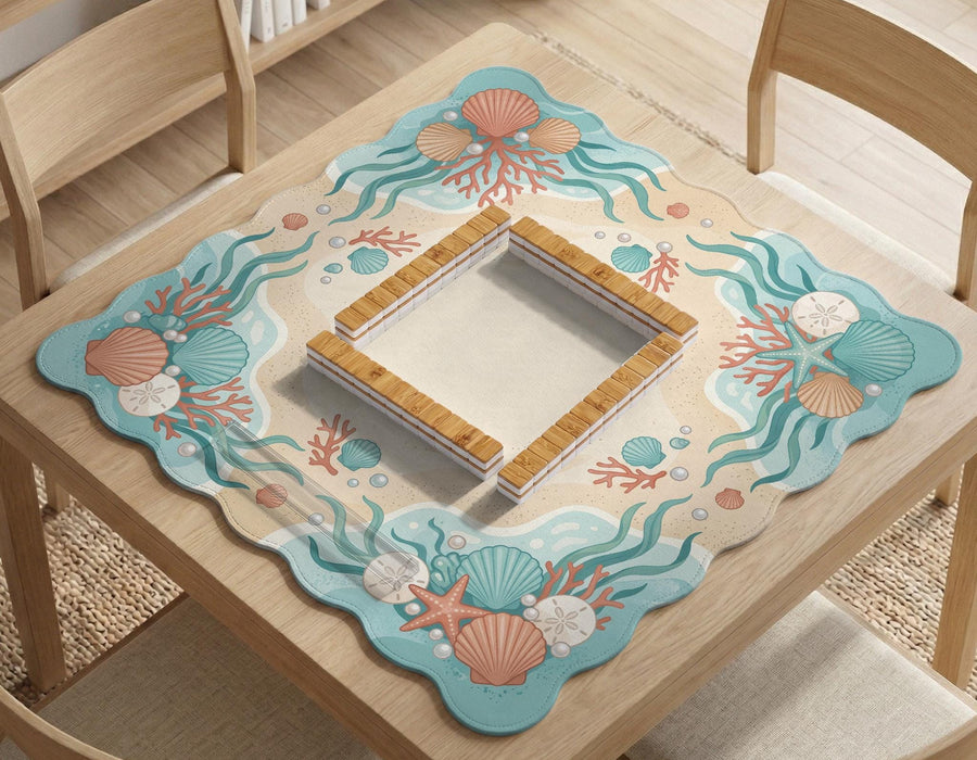 Pastel mahjong mat with a scalloped edge design featuring coral pink shells, aqua starfish, pearls, sand dollars, and a soft sea-inspired pattern.