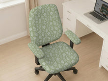 Sage green desk chair cover with a small floral and leaf print shown on an office chair.