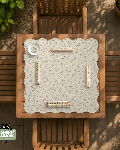 Cream square mahjong mat with a sage vine and leaf botanical pattern and scalloped edges.