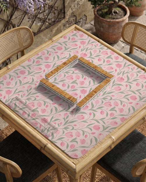 A pink mahjong mat with tulip flowers, sage leaves, and a light pastel background.