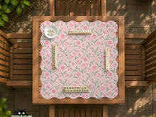 Pink mahjong mat with a tulip floral pattern in blush and sage tones and a scalloped edge.