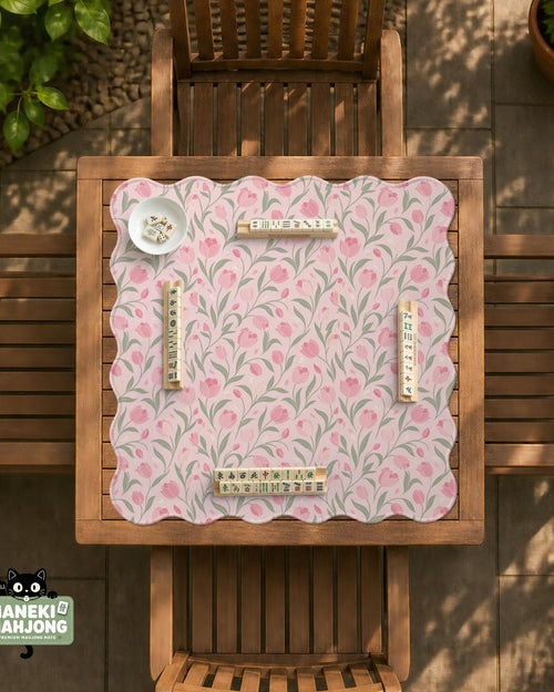 Pink mahjong mat with a tulip floral pattern in blush and sage tones and a scalloped edge.