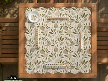 Green botanical mahjong mat with sage leaf and floral design and a scalloped edge.