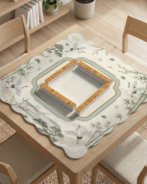 Ivory scalloped mahjong mat with flying cranes, bamboo stalks, blossom branches, and a framed center design.