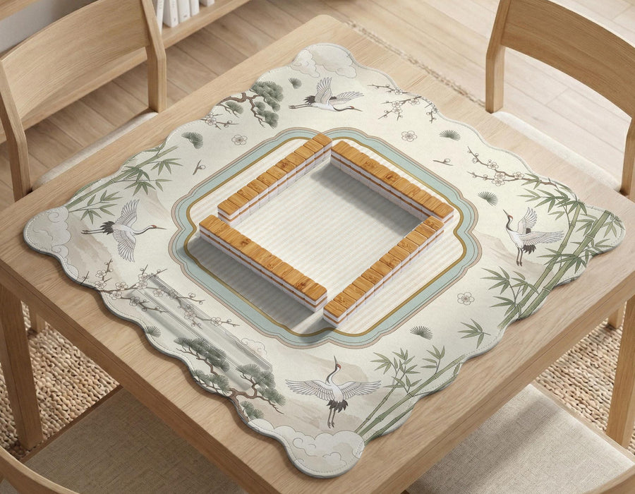 Ivory scalloped mahjong mat with flying cranes, bamboo stalks, blossom branches, and a framed center design.
