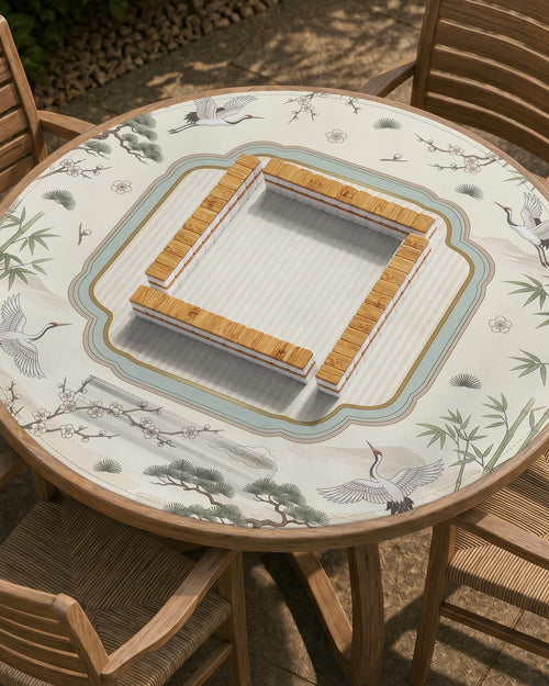 Square ivory mahjong mat with crane and bamboo pattern, a striped center, light blue border, and thin gold trim.