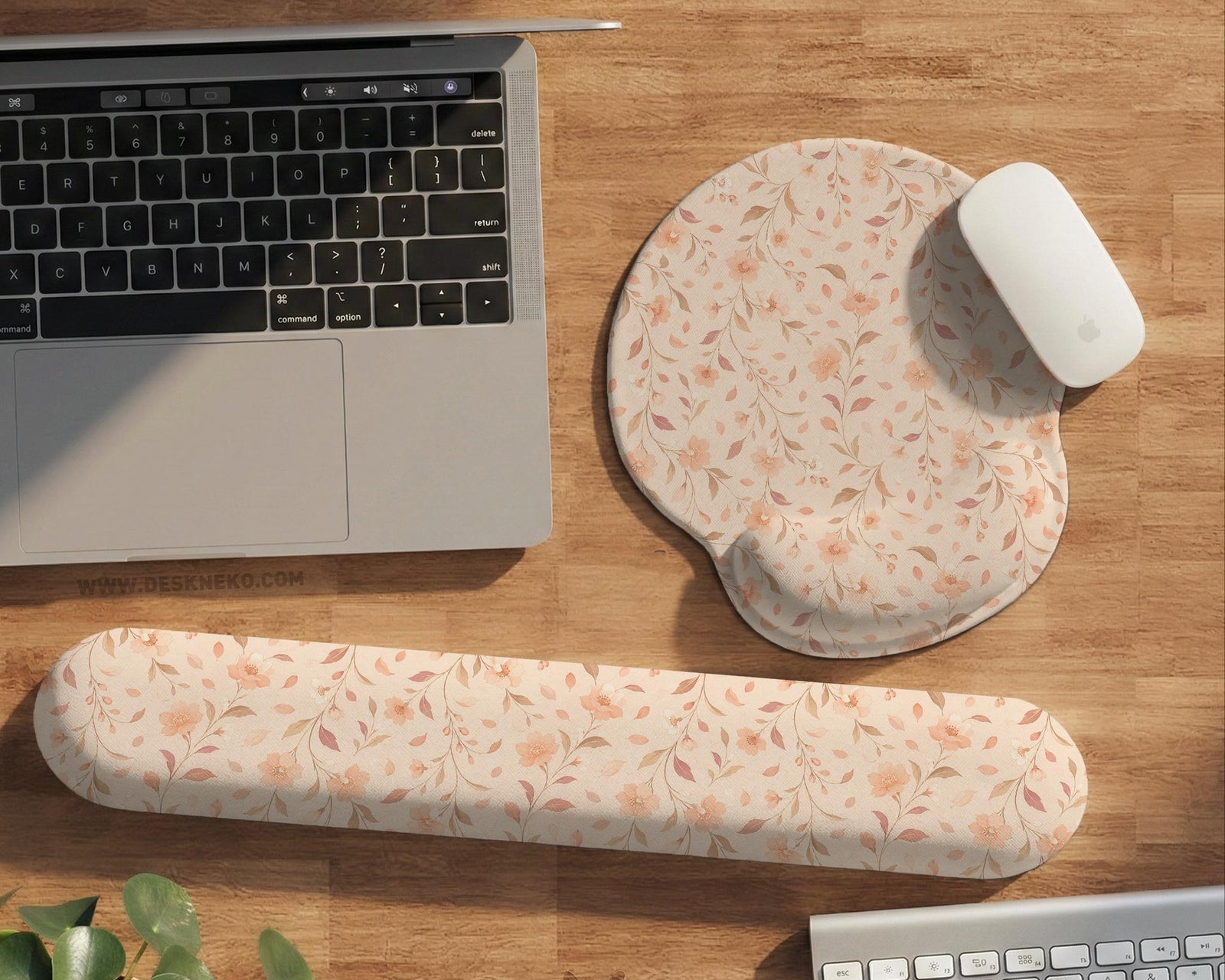 Blush pink floral mouse pad with wrist rest options, shown with peach blossoms, muted leaves, and a warm cream background.