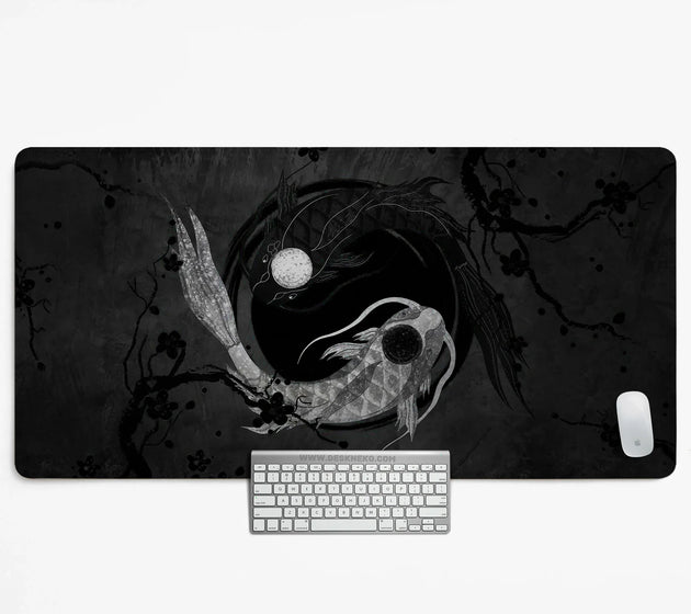 Black and white yin-yang koi desk mat with two koi fish, one silver and one black, circling a moon among ink plum blossom branches, shown with a keyboard and mouse