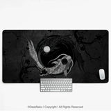 Black and white yin-yang koi desk mat with two koi fish, one silver and one black, circling a moon among ink plum blossom branches, shown with a keyboard and mouse