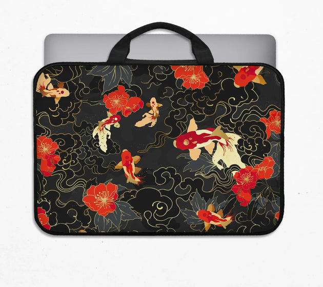 Padded koi fish laptop sleeve with black carry handles, printed with red, white and gold koi and red blossoms on a black and gold pattern, holding a laptop