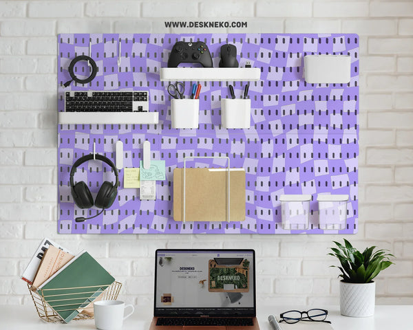 Pegboard wall organizer printed with a lavender wavy checkerboard pattern, holding a keyboard, game controller, headphones, pen cups and a folder on white shelves and hooks