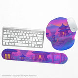 Ergonomic mouse pad and matching keyboard wrist rest printed with a purple twilight Japanese shrine scene with foxes, cherry blossoms and Mount Fuji, shown with a keyboard