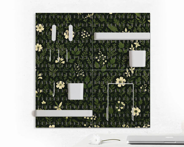 Pegboard wall organizer set printed with a dark botanical pattern of green foliage and pale cream flowers, fitted with white shelves, cups and hooks