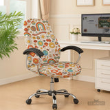 Office chair fitted with a stretch cover in a retro 1970s flower-power print with smiley daisies, rainbows, peace signs and mushrooms, shown in a home office