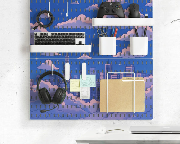 Anime pegboard wall organizer printed with a blue sky, pink clouds and a city skyline, holding a keyboard, game controller, headphones, pen cups and a folder on white shelves and hooks