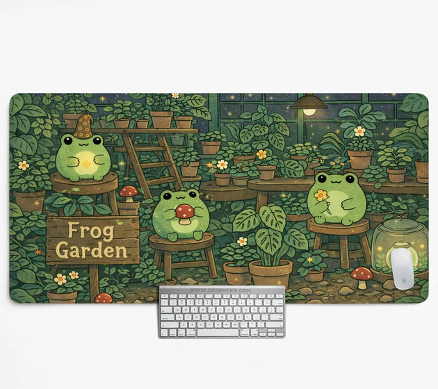 Frog garden desk mat illustrated with cute frogs in a cozy plant-filled greenhouse beside a wooden 'Frog Garden' sign, shown with a keyboard and mouse