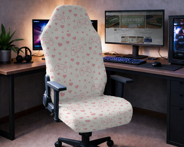 Gaming chair fitted with a cream stretch cover printed with pink game controllers, hearts and gaming symbols, shown in a gaming setup