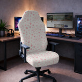 Gaming chair fitted with a cream stretch cover printed with pink game controllers, hearts and gaming symbols, shown in a gaming setup