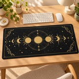 Black and gold Moon Phases desk mat on a sunlit oak workspace