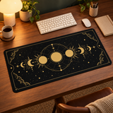 Black and gold Moon Phases desk mat in a warm evening workspace