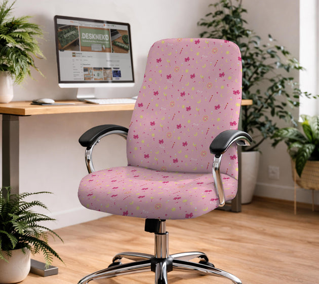 Pink chair cover with a pattern of moons, stars, bows, and small decorative shapes on a chair with armrests.