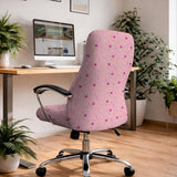 Pink chair cover with a pattern of moons, stars, bows, and small decorative shapes on a chair with armrests.