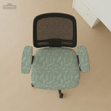 Office chair cover in muted sage green with a light leaf pattern on a white background.