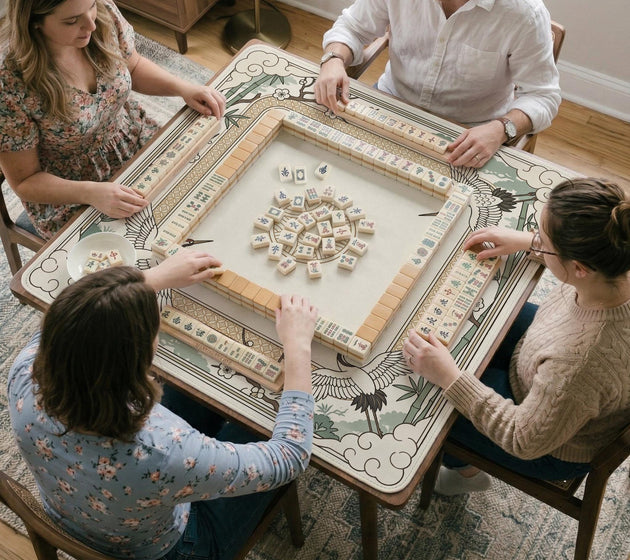 Square mahjong table mat with a cream center and a border design of cranes, bamboo, plum blossoms, and a geometric frame in sage green and warm gold.