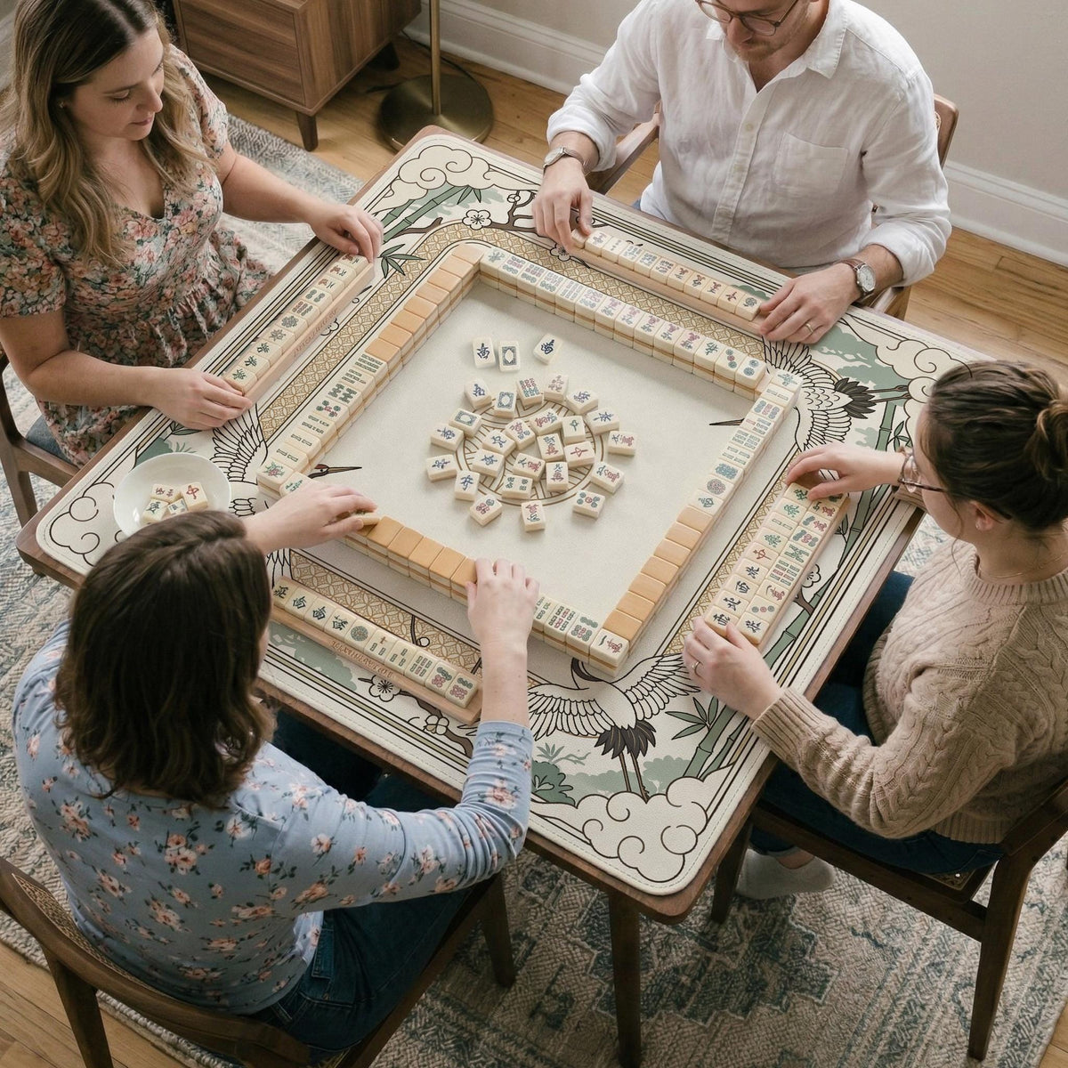 Square mahjong table mat with a cream center and a border design of cranes, bamboo, plum blossoms, and a geometric frame in sage green and warm gold.