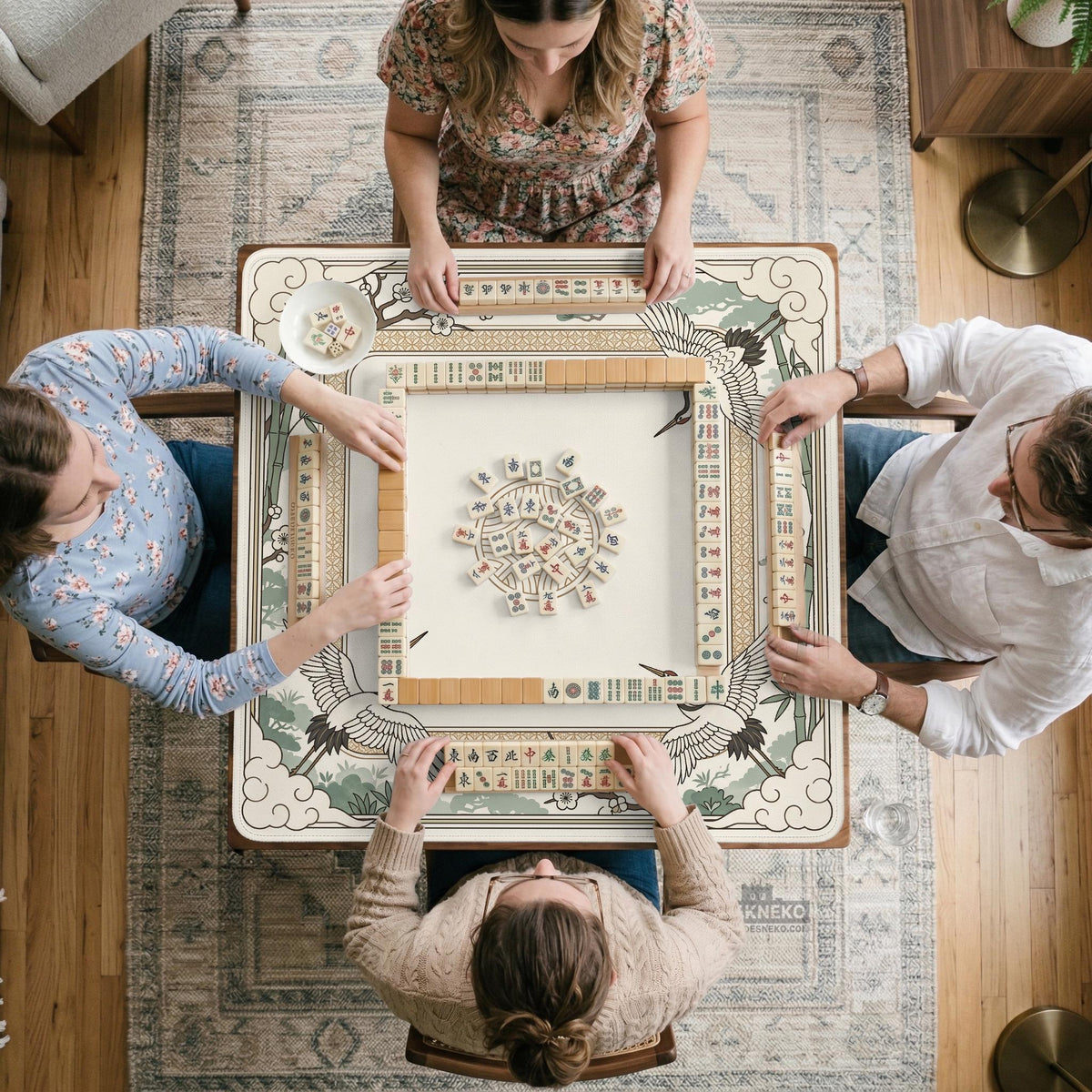 Square mahjong table mat with a cream center and a border design of cranes, bamboo, plum blossoms, and a geometric frame in sage green and warm gold.