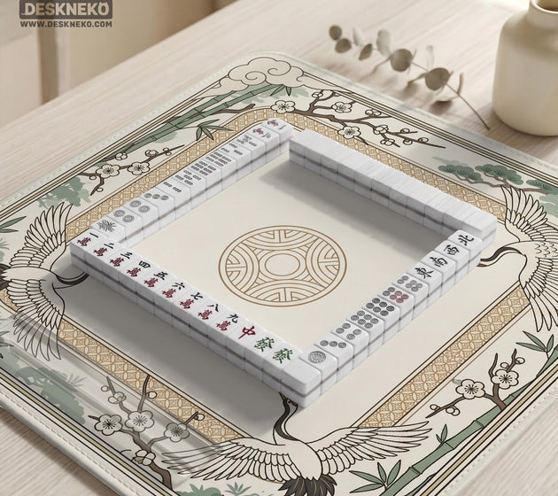 Square mahjong table mat with a cream center and a border design of cranes, bamboo, plum blossoms, and a geometric frame in sage green and warm gold.