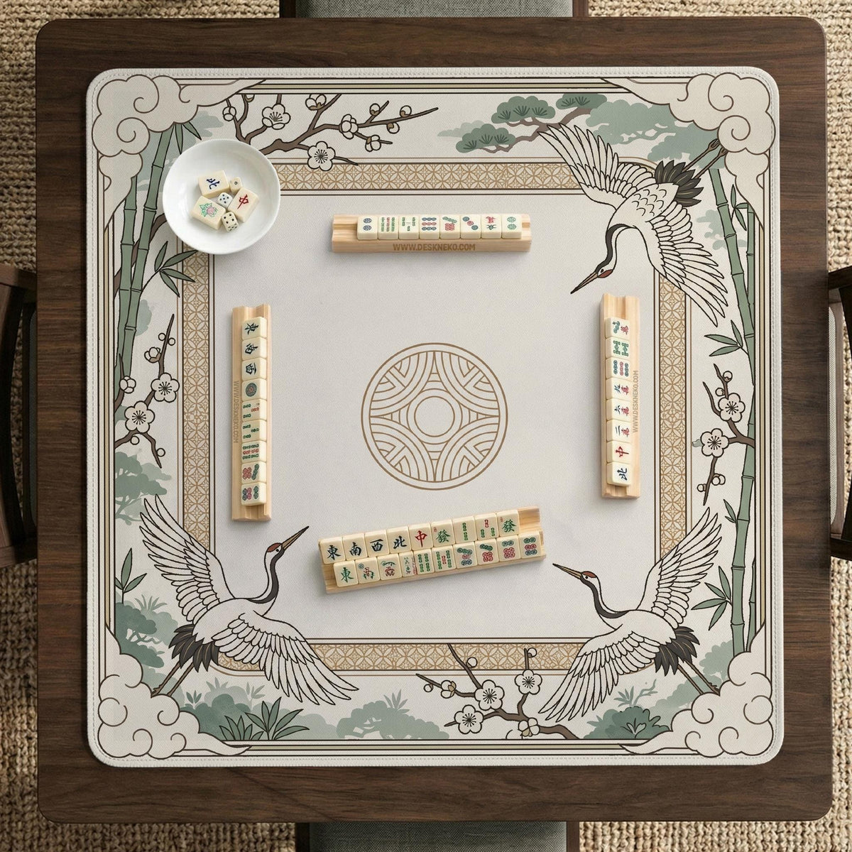 Square mahjong table mat with a cream center and a border design of cranes, bamboo, plum blossoms, and a geometric frame in sage green and warm gold.