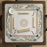Square mahjong table mat with a cream center and a border design of cranes, bamboo, plum blossoms, and a geometric frame in sage green and warm gold.