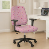 Pink chair cover with a pattern of moons, stars, bows, and small decorative shapes on a chair with armrests.