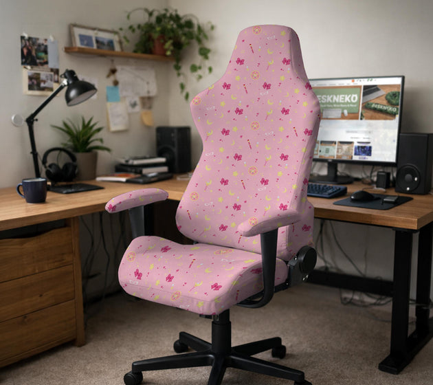 Pink chair cover with a pattern of moons, stars, bows, and small decorative shapes on a chair with armrests.