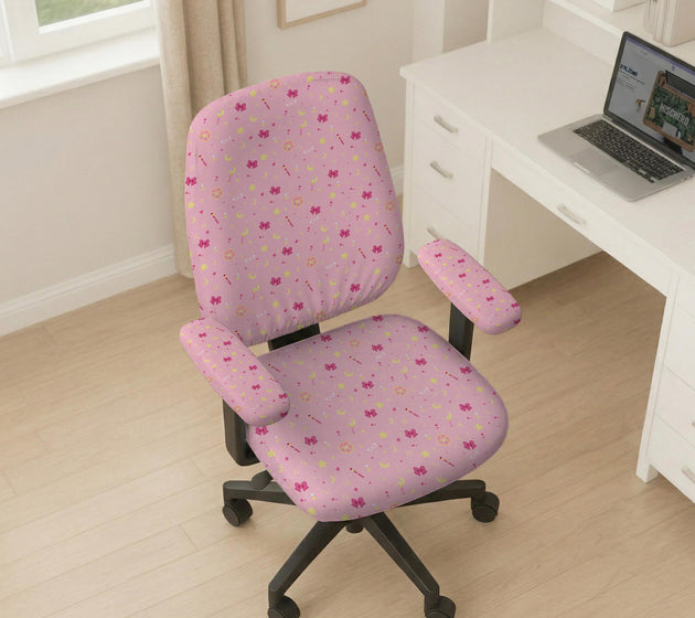 Pink chair cover with a pattern of moons, stars, bows, and small decorative shapes on a chair with armrests.