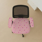 Pink chair cover with a pattern of moons, stars, bows, and small decorative shapes on a chair with armrests.