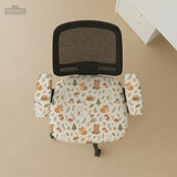 A gaming chair cover with a woodland animal print featuring foxes, rabbits, bears, mushrooms, and leaves in green, brown, and beige tones.