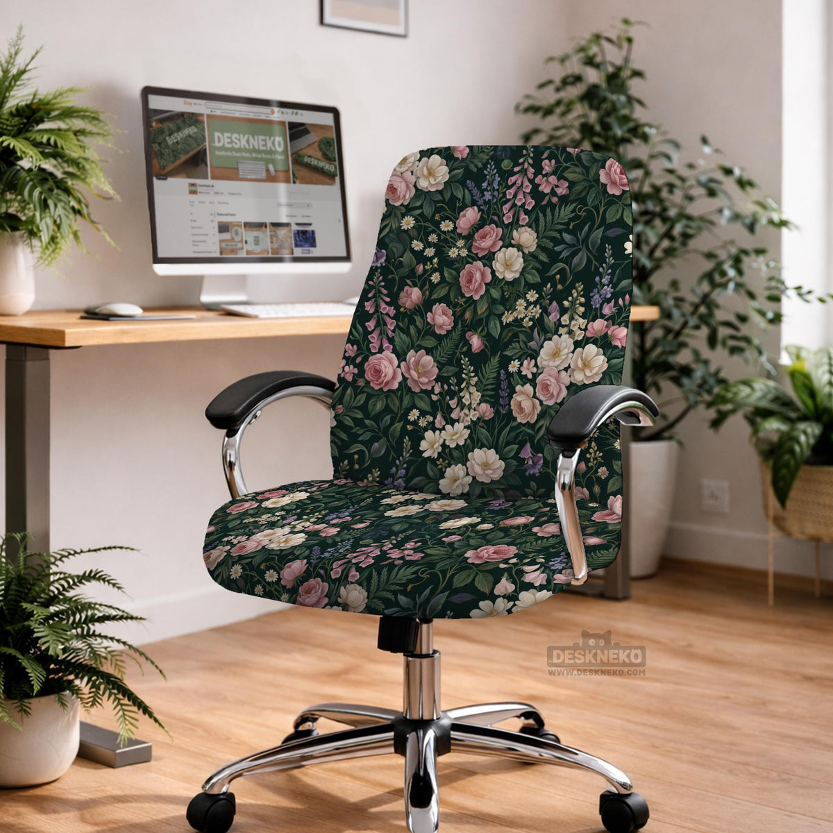 Green chair cover with a dark floral pattern, pink roses, cream flowers, and leafy botanical details on an office chair.